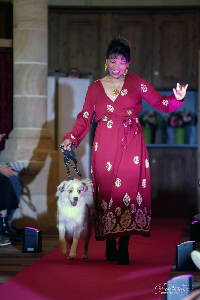 Défilé Tapis Rose à Moulins : une patiente en robe rouge défile avec son chien sur le tapis rouge